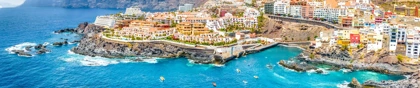 Scenic view of Los Gigantes, Tenerife, with colorful buildings perched on cliffs overlooking the blue Atlantic Ocean