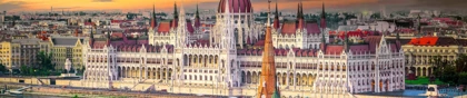 View of the Hungarian Parliament Building in Budapest, Hungary, with the Danube River in the foreground at sunset
