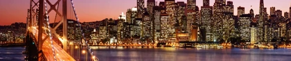 San Francisco skyline at night with the illuminated Bay Bridge in the foreground