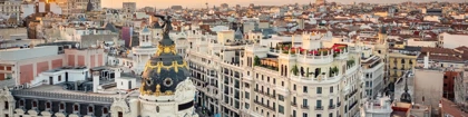 Aerial view of Gran Vía in Madrid at sunset, featuring the iconic Metropolis Building