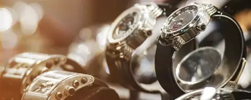 A selection of luxury wristwatches is arranged in a jewelry display case. The high-value items illustrate the need for secure, carefully managed transportation and specialized logistics solutions.