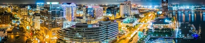 Norfolk, Virginia skyline at night with illuminated buildings, streets, and a waterfront marina
