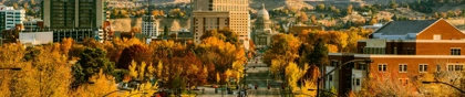 Downtown Boise, Idaho in autumn, with golden foliage, the State Capitol building, and mountains in the background