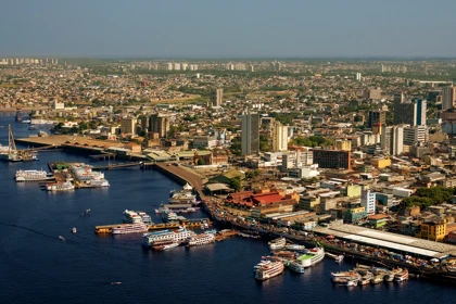 Aerial view of Manaus, Brazil, with busy river docks and passenger boats supporting Scan Global Logistics networks.